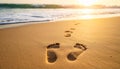 Footprints in sand with approaching waves at sunset Royalty Free Stock Photo