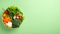 Bowl of mixed fresh vegetables on matte pastel green gradient background, symbolizing healthy nutrition Royalty Free Stock Photo