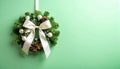 Tiny Christmas wreath with ribbon on matte pale green gradient Royalty Free Stock Photo