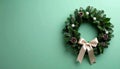 Tiny Christmas wreath with ribbon on matte pale green gradient Royalty Free Stock Photo