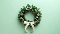 Tiny Christmas wreath with ribbon on matte pale green gradient Royalty Free Stock Photo