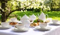 generated using AI.Outdoor dining setup features a white tablecloth with tea sets, including teapots and cups, arranged on plates Royalty Free Stock Photo