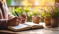 Hands journaling in open notebook with herbal tea, warm neutral tones Royalty Free Stock Photo