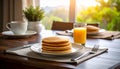 Close-up of dark wooden table with one plate of pancakes, glass of orange juice, fork, and knife Royalty Free Stock Photo