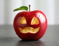 Apple with crying face on grey table, closeup. Concept of jealousy Royalty Free Stock Photo