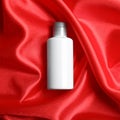 Bottle of hair care cosmetic product on red fabric, top view Royalty Free Stock Photo