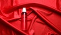 Bottle of hair care cosmetic product on red fabric, top view Royalty Free Stock Photo