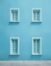 Light blue wall with four symmetrically arranged windows. Royalty Free Stock Photo