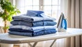Neatly stacked freshly ironed shirts on ironing board in bright airy room Royalty Free Stock Photo