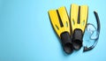 Pair of yellow flippers and mask on light blue background, flat lay. Space for text Royalty Free Stock Photo
