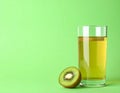 Glass of refreshing drink and cut kiwi on green background, space for text Royalty Free Stock Photo