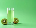 Glass of refreshing drink and cut kiwi on green background, space for text Royalty Free Stock Photo