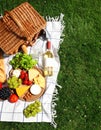 Flat lay composition with picnic basket and products on checkered blanket outdoor Royalty Free Stock Photo