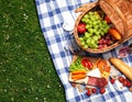 Flat lay composition with picnic basket and products on checkered blanket outdoor Royalty Free Stock Photo