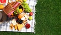 Flat lay composition with picnic basket and products on checkered blanket outdoor Royalty Free Stock Photo