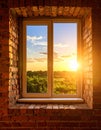 Exposed brick wall with tall window, warm golden sunlight, summer sky Royalty Free Stock Photo