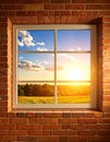 Exposed brick wall with tall window, warm golden sunlight, summer sky Royalty Free Stock Photo