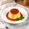 Karamel soslu lezzetli puding ve sofrada nane Royalty Free Stock Photo