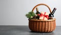 Wicker basket with gift set and Christmas decor on grey table. Space for text Royalty Free Stock Photo