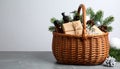 Wicker basket with gift set and Christmas decor on grey table. Space for text Royalty Free Stock Photo