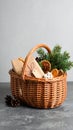 Wicker basket with gift set and Christmas decor on grey table. Space for text Royalty Free Stock Photo