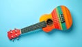 Colorful ukulele on light blue background, top view. String musical instrument Royalty Free Stock Photo