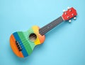 Colorful ukulele on light blue background, top view. String musical instrument Royalty Free Stock Photo