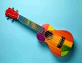 Colorful ukulele on light blue background, top view. String musical instrument Royalty Free Stock Photo