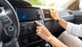 Listening to radio while driving. Woman turning volume button on vehicle audio in car Royalty Free Stock Photo