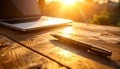Wooden desk with laptop and pen, afternoon sun streaming in, subtle reflections Royalty Free Stock Photo