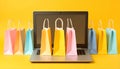 Online shopping. Laptop computer and colored paper bags on a yellow background Royalty Free Stock Photo