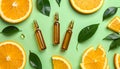 Skincare ampoules with vitamin C, slices of orange and leaves on light green bnd Royalty Free Stock Photo
