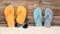 Bright flip flops and sunglasses on sand near wooden wall, space for text. Summer beach Royalty Free Stock Photo