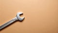 Matte light brown background with a single wrench diagonally in bottom-left corner Royalty Free Stock Photo