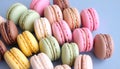 Collection of colorful macarons arranged closely together on a light blue surface. Royalty Free Stock Photo