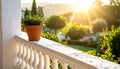 White stone balcony with single terracotta pot, overlooking sunlit garden, warm morning light, top-right angle Royalty Free Stock Photo