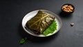 generated using AI.Stuffed grape leaves, likely dolmas, are neatly arranged on a white plate with a dark rim, Royalty Free Stock Photo