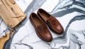 generated using AI.Brown leather loafers on a white and black marbled surface. Royalty Free Stock Photo