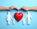 Paper family figures and red heart on light blue background, flat lay. Insurance Royalty Free Stock Photo