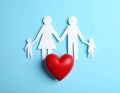 Paper family figures and red heart on light blue background, flat lay. Insurance Royalty Free Stock Photo