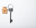 Keys with trinket in shape of house on white background, top view and space for text. Royalty Free Stock Photo