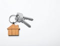 Keys with trinket in shape of house on white background, top view and space for text. Royalty Free Stock Photo
