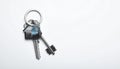Keys with trinket in shape of house on white background, top view and space for text. Royalty Free Stock Photo