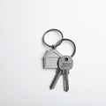 Keys with trinket in shape of house on white background, top view and space for text. Royalty Free Stock Photo