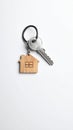 Keys with trinket in shape of house on white background, top view and space for text. Royalty Free Stock Photo