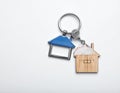 Keys with trinket in shape of house on white background, top view and space for text. Royalty Free Stock Photo