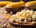 Delicious popcorn and corn kernels on a wooden table. Royalty Free Stock Photo