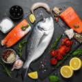 Fresh dorado fish and other seafood on black slate background, flat lay Royalty Free Stock Photo