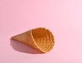 Empty wafer ice cream cone on pale pink background Royalty Free Stock Photo