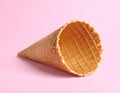 Empty wafer ice cream cone on pale pink background Royalty Free Stock Photo